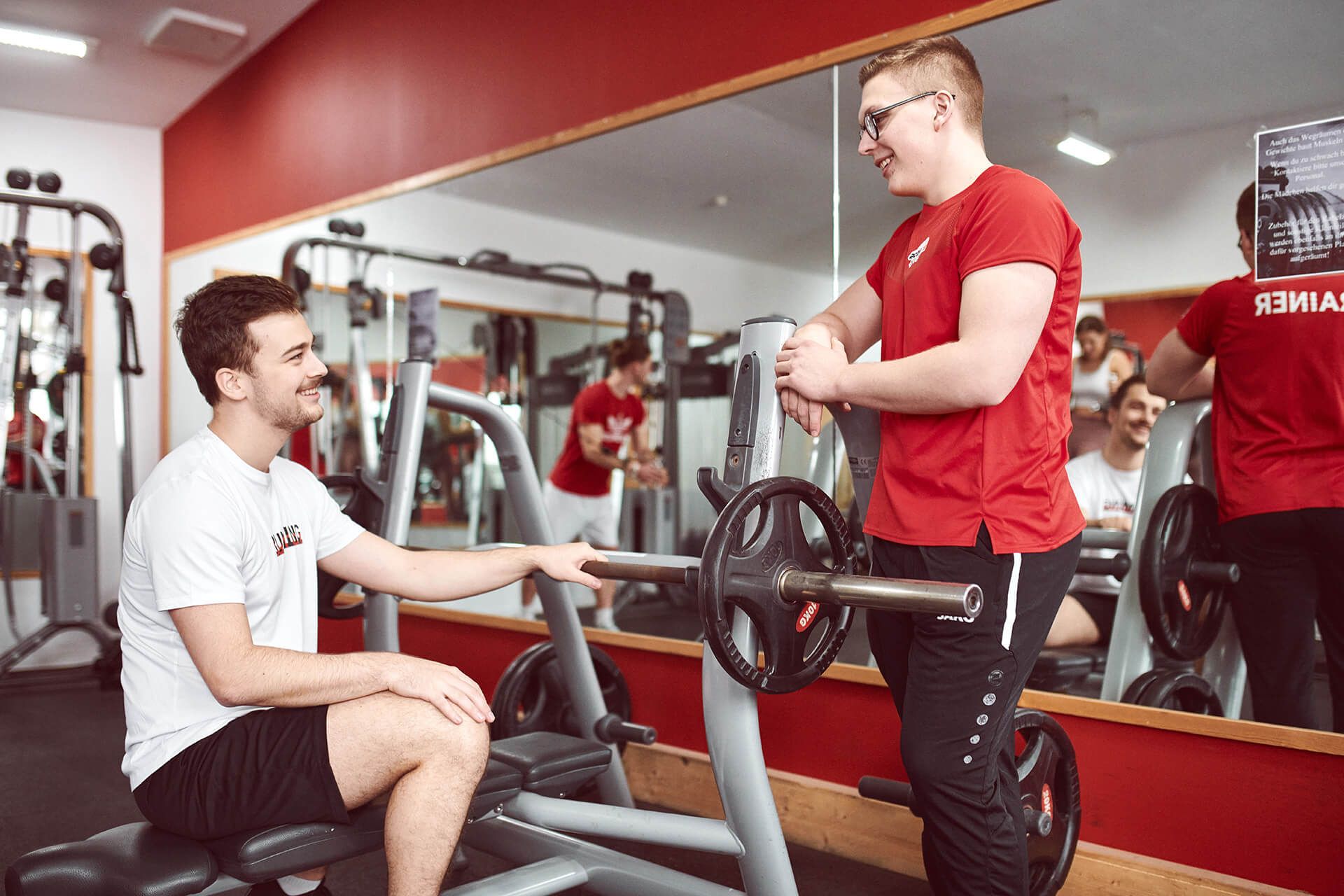 Mann mit Trainer beim Brustdrücken im Fitness Unlimited Fitnessstudio in Berlin Charlottenburg