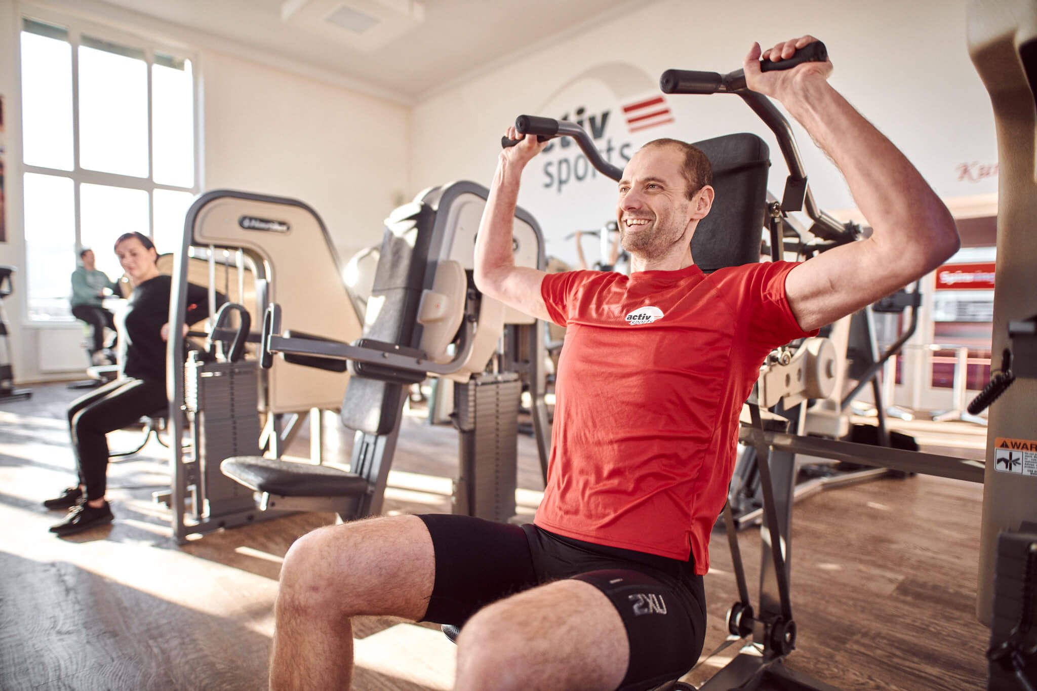 Mann beim Schulterdrücken im Premium Fitnessstudio activsports in Halle